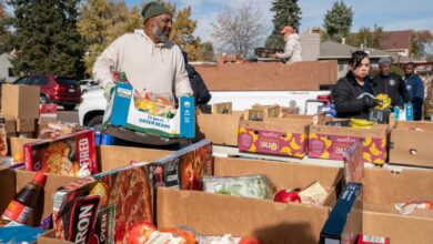 داوطلبان موسسه خیریه پارک هیل فود پنتری در حال پر کردن و مرتب کردن جعبههای اهدای غذا در طول توزیع غذای هفتگی - اطلس دیپلماسی
