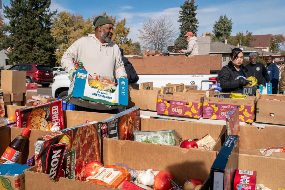 داوطلبان موسسه خیریه پارک هیل فود پنتری در حال پر کردن و مرتب کردن جعبه‌های اهدای غذا در طول توزیع غذای هفتگی - اطلس دیپلماسی