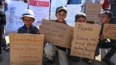 کودکان غزه پلاکارد در دست در صف کمکهای بشردوستانه _ اطلس دیپلماسی