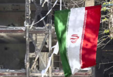 پرچم ایران در میان ویرانه های ناشی از بمباران