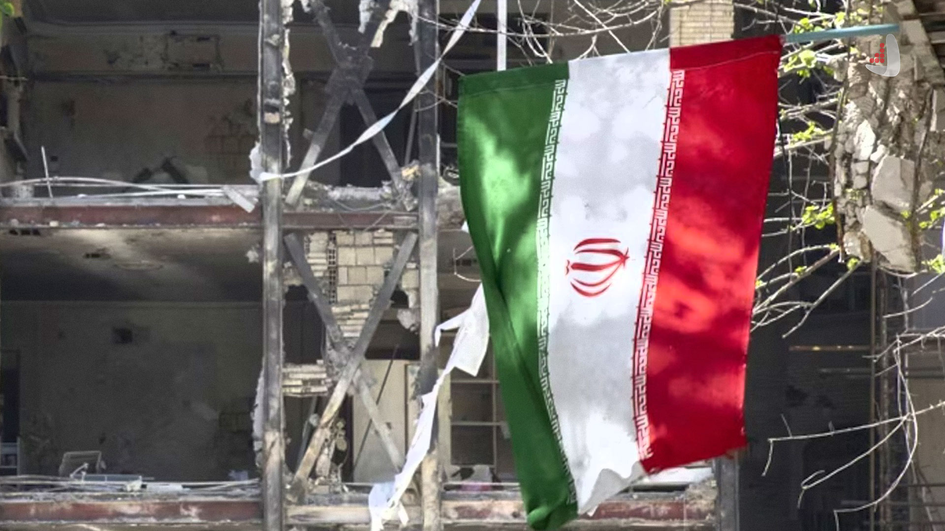 پرچم ایران در میان ویرانه های ناشی از بمباران