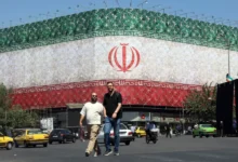 تصویری از میدان انقلاب تهران که در آن پرچم ملی ایران بر روی یک ساختمان نقش بسته است
