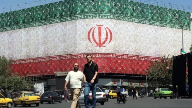 تصویری از میدان انقلاب تهران که در آن پرچم ملی ایران بر روی یک ساختمان نقش بسته است