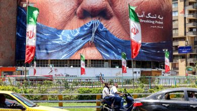 بیلبورد بزرگی در تهران با تصویر دهان بسته شده با پلاستیک آبی و عبارت به تنگ آمدن در کنار پرچم‌های ایران