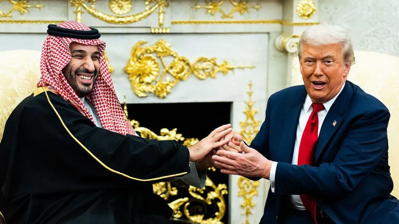 دونالد ترامپ با کت و شلوار تیره و کراوات قرمز در حال دست دادن با محمد بن سلمان با چفیه و عقال عربی در یک سالن مجلل