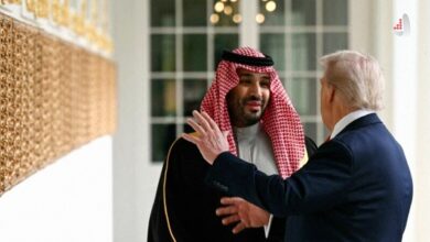 محمد بن سلمان ولیعهد عربستان با لباس سنتی چفیه و عقال در حال گفتگو با دونالد ترامپ از نمای پشت سر در یک راهرو رسمی.