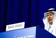 عبدالعزیز بن سلمان وزیر انرژی عربستان با چفیه سفید پشت تریبون رسمی کشور عربستان سعودی با نوشته اتم برای صلح.