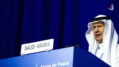 عبدالعزیز بن سلمان وزیر انرژی عربستان با چفیه سفید پشت تریبون رسمی کشور عربستان سعودی با نوشته اتم برای صلح.