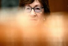 پرتره فوکوس‌شده از سوزان کالینز (Susan Collins)، سناتور آمریکایی با عینک، در یک جلسه رسمی با پس‌زمینه تار و محو