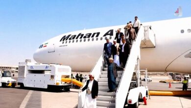مسافران و مقامات یمنی با پوشش سنتی در حال پیاده شدن از هواپیمای ایرباس شرکت ماهان ایر در باند فرودگاه صنعا