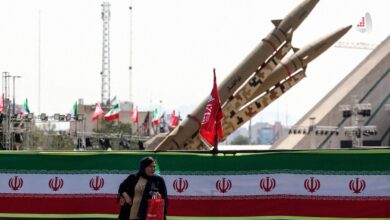 موشک‌های بالستیک ذوالفقار سپاه پاسداران در نمایشگاه نظامی تهران با بنر پرچم ایران و عبور عابران پیاده
