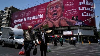 بیلبورد بزرگ میدان ولیعصر تهران با نقاشی چهره وحشت‌زده دونالد ترامپ و شعار انتقام حتمی است به همراه عابران پیاده در خیابان