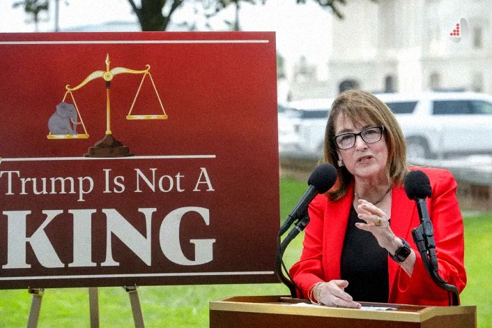 سخنرانی امی کلوبوچار سناتور دموکرات در کنار تابلو "Trump Is Not A KING"