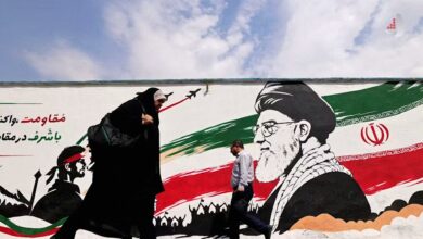عابران در مقابل دیوارنگاره ای با پرچم ایران در تهران