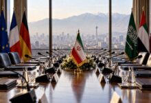 میز مذاکره با پرچم های ایران، کشورهای اروپایی و عربی با چشم انداز شهر تهران